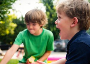 family and kids laugh at a picnic